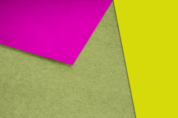 Plain and Textured neon pink yellow green papers randomly laying to form M like pattern and triangle for creative cover design idea