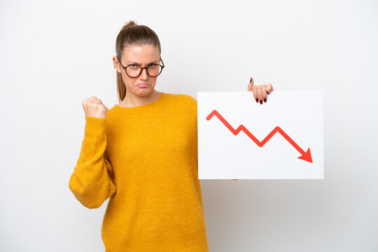 Young caucasian woman isolated on white background holding a sign with a decreasing statistics arrow symbol and angry