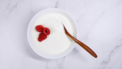 Fermented natural yoghurt with raspberries as a top view
