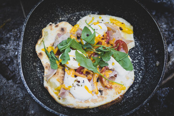 preparing a flatbread for dinner. cooking in a frying pan over a campfire while camping