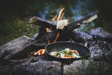 preparing a flatbread for dinner. cooking in a frying pan over a campfire while camping