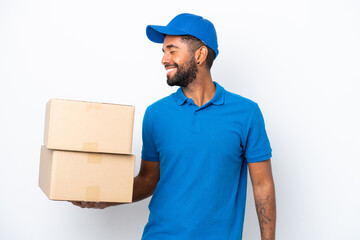 Delivery Brazilian man isolated on white background laughing in lateral position