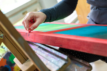 Female artist painting abstract painting in her professional studio