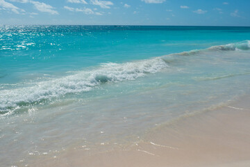 Caribbean Sea. A beautiful beach with white sand, a turquoise wave runs onto the shore. Relaxing landscape without people