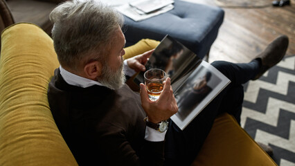 Grey hair man drinking whiskey and reading journal