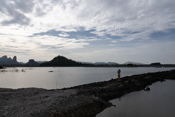 Landscpae of Mountain and Lake with Silhouette of People Walking on ridge in Lopuri Thailand