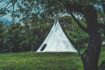 white teepee indian tent standing in beautiful landscape.