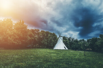 white teepee indian tent standing in beautiful landscape.
