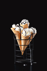 Fototapeta na wymiar Cones of homemade vanilla ice cream with chocolate on a dark background