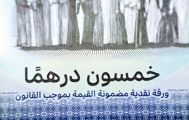 Translation of Arabic Text (Fifty Emirates Dirhams) from the obverse side of the new polymer commemorative 50 fifty Dirhams with Memorial to the martyrs of the Emirates UAE, selective focus