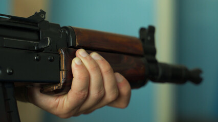 a soldier in camouflage uniform takes aim with his machine gun, preparing to fire close-up....