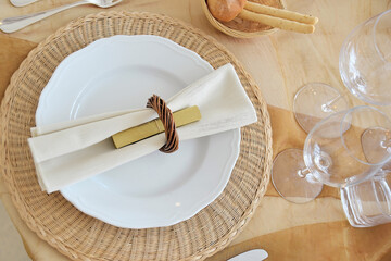 Detail of a table set in ocher color organza for a wedding banquet
