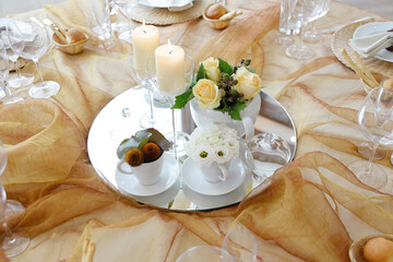 Detail of a table set in ocher color organza for a wedding banquet