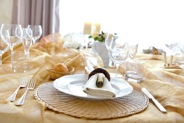 Detail of a table set in ocher color organza for a wedding banquet