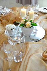 Detail of a table set in ocher color organza for a wedding banquet