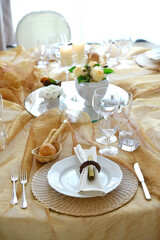 Detail of a table set in ocher color organza for a wedding banquet