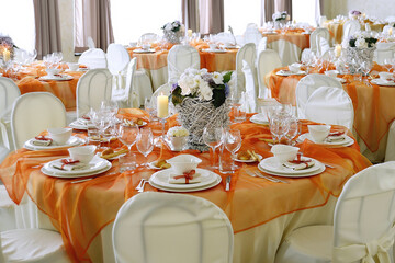Table set in orange organza for a wedding banquet