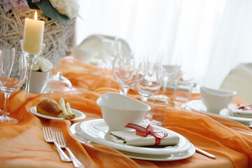 Table set in orange organza for a wedding banquet