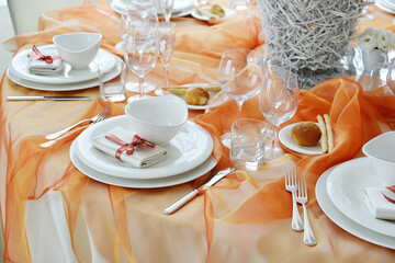Table set in orange organza for a wedding banquet