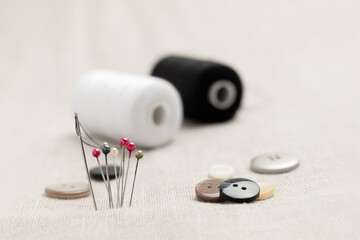 Spool of thread and needles for sewing, close-up