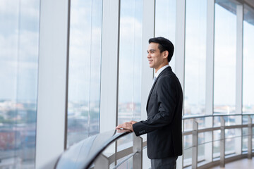 Young asian business man stand looking away , smart business concept.