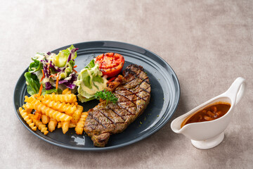 Grilled Sirloin Beef Steak with french fries and salads. Serve on Black Plate. Negative Space.