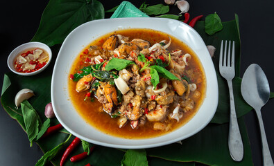 Stir fried mixed basil with shrimp, mussels, minced pork and squid mixed together. street food thailand asia