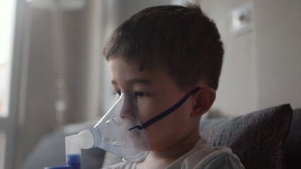 A kid breathing steam from an inhaler. Treatment of lung diseases