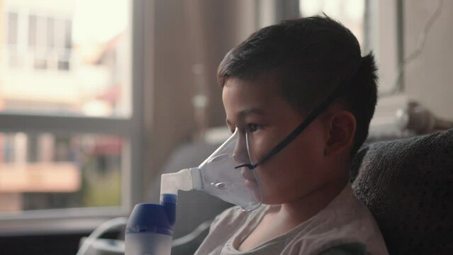 A kid breathing steam from an inhaler. Treatment of lung diseases