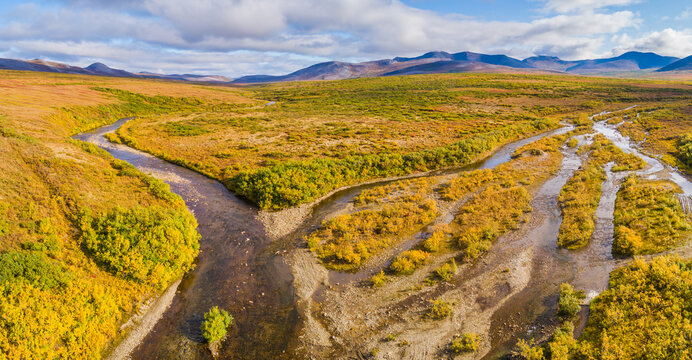 Aerial view over tundra landscape  in autumn colors with mountains and meandering rivers in the vicinity of Nome, Alaska