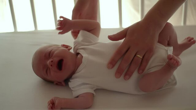 mother picking up and comforting her crying newborn baby