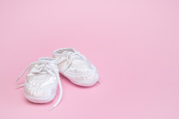 booties for a newborn on a pink background copy space