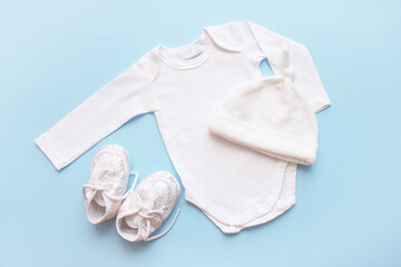 bodysuit for a newborn, cap and booties on a blue background