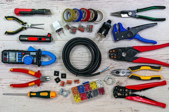 Professional electrician tools and electrical components on light wooden boards - Powered by Adobe