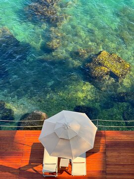 Beach and sea. Beach umbrella and chairs on the rocky sea shore. Summer. Relax. Vacation.