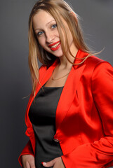 Fototapeta premium beautiful young woman in red suit with a smile. studio shot