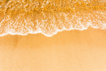 Soft beautiful sea wave on sandy beach. Water bright background.Top view.Copy space.