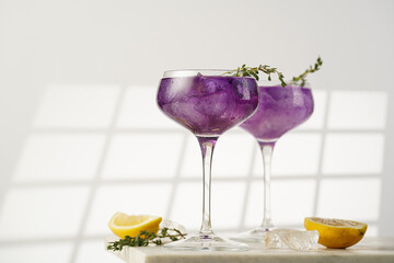 a purple drink in a vintage glass for sparkling wine - pea flower tea or blue curacao sirup...
