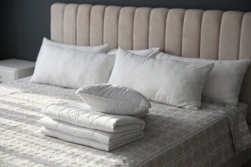 Fototapeta na wymiar Folded clean blanket and pillow on bed in room
