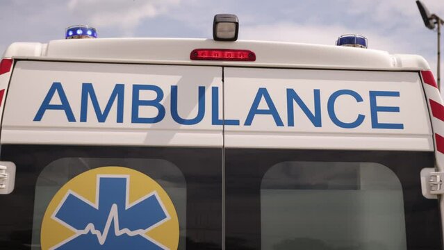 A white ambulance van on a wide city street, with warning lights and sirens, Metropolis Rescue Services vehicle, ambulance car responding in hazardous conditions, close up.