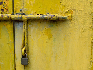 Rusted yellow painted metal door and old master key.