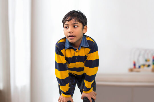 An Indian boy bending forward and looking Away