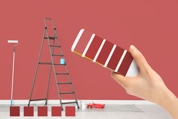 Decorator holding color palette samples in room with painted wall, closeup. Interior renovation