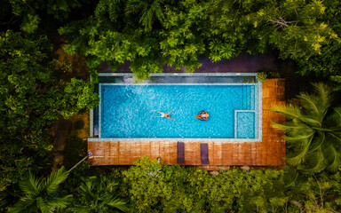 couple of men and women in a swimming pool in the jungle of Krabi Thailand, aerial view with a...
