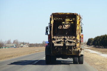 Garbage truck on the road back view