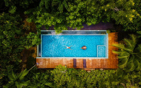 Couple Of Men And Women In A Swimming Pool In The Jungle Of Krabi Thailand, Aerial View With A Drone Above Swimming Pool In The Jungle Of Thailand.