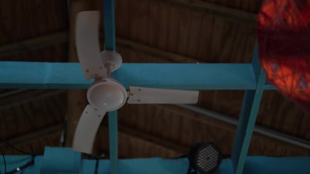 Ventilador de techo dando vueltas en techo de madera