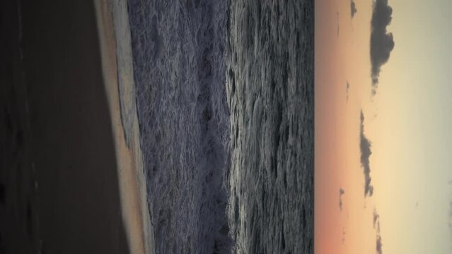 Imagen de la playa al atardecer con el mar moviendose