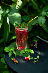 Raspberry, basil detox water, lemonade, Summer cold drink on a black background, outdoor garden fresh bush, sunlight, Vegan, diet, organic natural