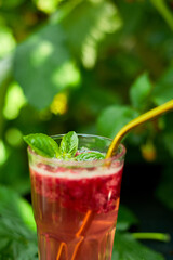 Raspberry, basil detox water, lemonade, Summer cold drink on a black background, outdoor garden fresh bush, sunlight, Vegan, diet, organic natural